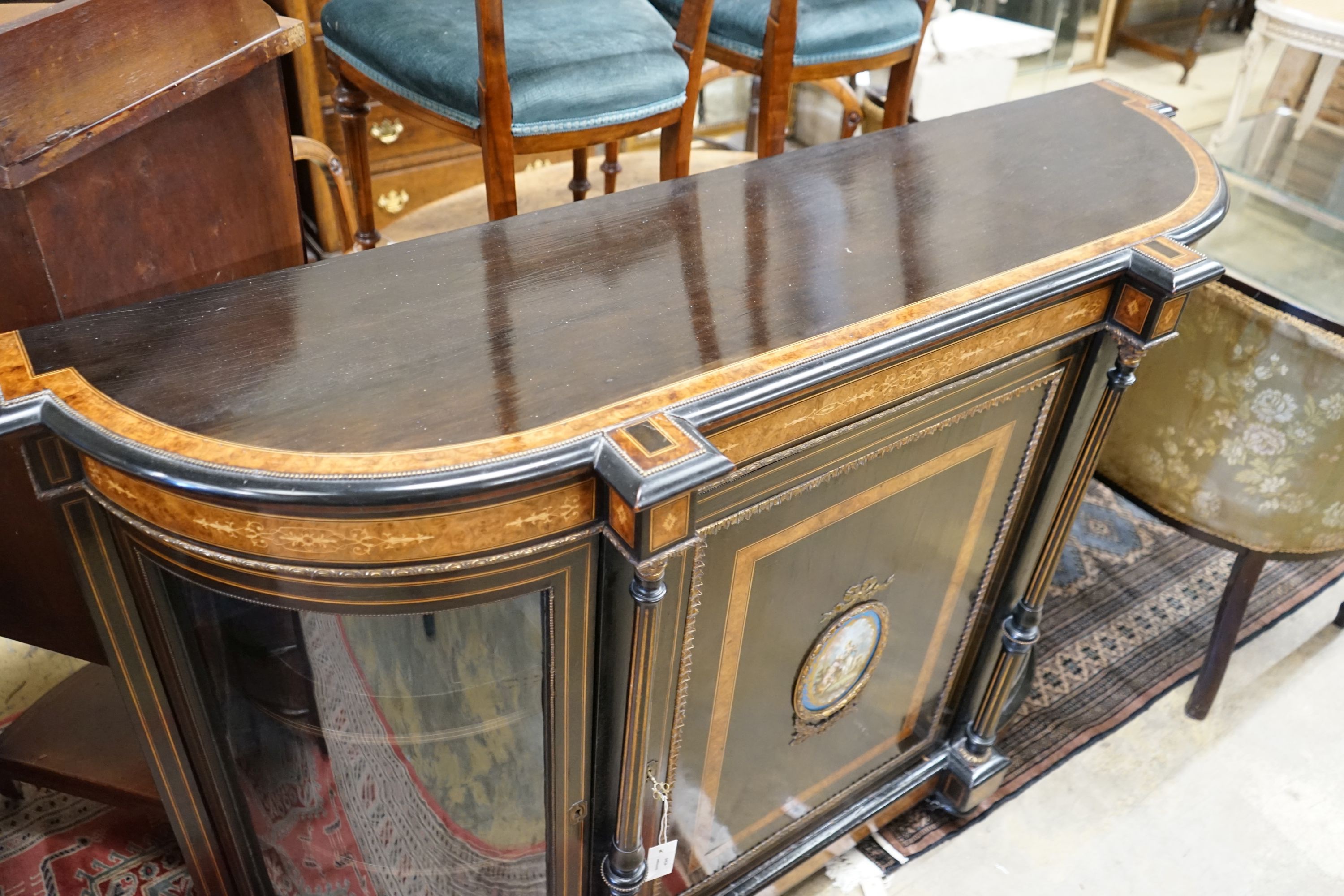 A late Victorian ebonised and amboyna banded credenza, with inset Sevres style porcelain panel, width 154cm, depth 45cm, height 107cm